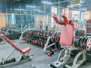 a gym with lots of exercise equipment and a red chair at GreenTree Eastern Hotel Suqian Sihong Executive Center in Sihong