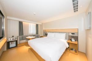 1 dormitorio con 1 cama blanca grande y 1 sofá en JI Hotel Beijing Dazhongsi, en Beijing