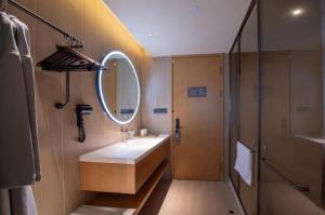 a bathroom with a sink and a mirror and a shower at JI Hotel Beijing Dazhongsi in Beijing