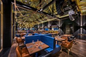 a restaurant with wooden tables and blue booths at Blossom House Beijing Houhai in Beijing