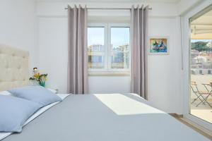 a white bedroom with a bed and a window at Hedera Estate Hedera A43 in Dubrovnik