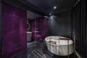 Baño púrpura con bañera y 2 lavabos en Blossom House Beijing Houhai, en Beijing