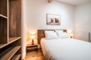 a bedroom with a large white bed and two lamps at Apartment Edelweiss Les Gets - BY EMERALD STAY in Les Gets