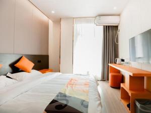 um quarto com uma cama, uma secretária e uma televisão em Shell Hotel Anhui Chuzhou City Jinzhou Dawang Ying Road em Chuzhou