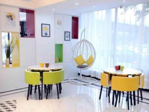 une salle à manger avec deux tables et des chaises jaunes dans l'établissement GreenTree Inn Shenyang Huanggu District Union Building, à Shenyang