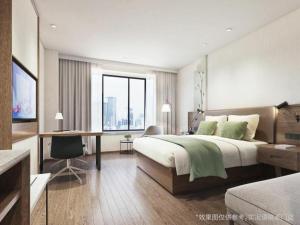 a bedroom with a large bed with a desk and a desk at GreenTree Inn Shangrao Wuyishan Avenue Meide Yinxiang in Shangrao