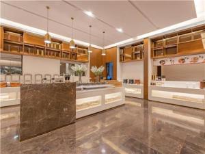 uma grande cozinha com pisos em mármore e armários de madeira em E-Cheng Hotel Dali High-Speed Railway Station Erhai Lake em Dali