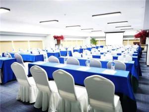 Habitación grande con mesas azules y sillas blancas. en E-Cheng Hotel Dali High-Speed Railway Station Erhai Lake, en Dali