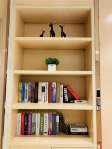 a book shelf with books and two black cats on it at City Comfort Inn Guangzhou Sun Yat-sen Memorial Hospital Yide Road Metro Station in Guangzhou