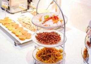 a buffet with three tiers of food on a table at City Comfort Inn Yongzhou Xiaoxiang Bridge Xinhua Bookstore in Guzhuting