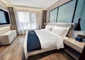 開封市にあるEcharm Hotel Kaifeng Jinming Square Henan Universityの大きなベッドルーム(大型ベッド1台、ソファ付)