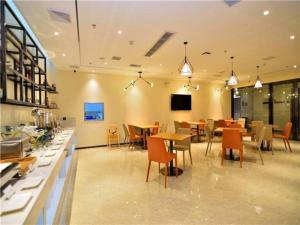 a restaurant with tables and chairs in a room at City Comfort Inn Kunming Flower City Midea Shuncheng Mansion in Kunming