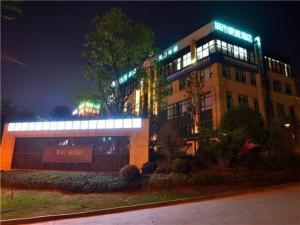 a building with lights on top of it at night at City Comfort Inn Kunming Flower City Midea Shuncheng Mansion in Kunming