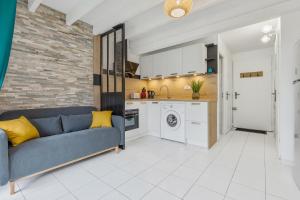 a living room with a blue couch and a kitchen at Villa Forlittoral in Le Grau-dʼAgde