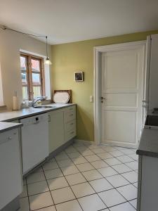 an empty kitchen with a sink and a door at Kerteminde-ferielejlighed in Kerteminde