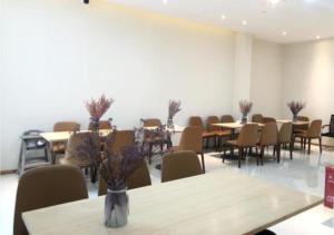 una stanza con tavoli e sedie e una fila di tavoli di City Comfort Inn Lhasa Gongga County Gongga Airport 