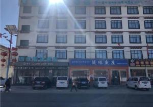 にあるCity Comfort Inn Lhasa Gongga County Gongga Airportの車が目の前に停まった大きな建物