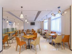 南寧的住宿－City Comfort Inn Nanning Keyuan Avenue Metro Station，用餐室设有桌椅和窗户。