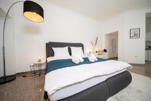 a bedroom with a large bed with towels on it at Apartments - Kitchen & More in Düsseldorf