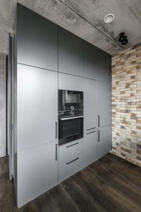a kitchen with white cabinets and a stove at Boutique Studio with Parking & AC by Hostlovers in Kaunas