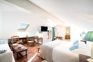 1 dormitorio con 1 cama y sala de estar en La Ferme D'Augustin, en Saint-Tropez