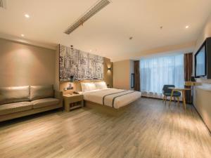 a hotel room with a bed and a couch at City Comfort Inn Shiyan High-speed Railway Wanda Plaza in Shiyan