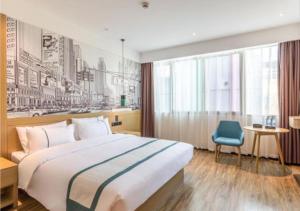 una camera d'albergo con un grande letto e una sedia blu di City Comfort Inn Quanzhou Wanda a Donghai