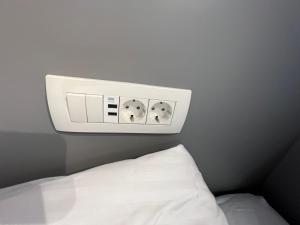 a clock on the wall above a bed at Studio Spark Ljubljana in Ljubljana