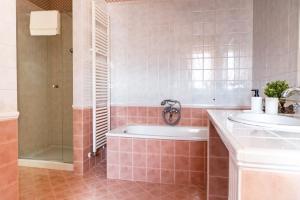 een badkamer met een bad, 2 wastafels en een douche bij CASA CON VISTA in Potenza Picena
