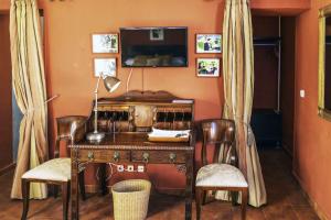 a room with a wooden desk with chairs and a television at Hotel Utopía by MA 22 Puntos in Benalup Casas Viejas