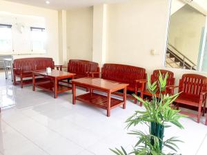 uma sala de espera com bancos e mesas e um espelho em SC Palace Chiangrai Hotel em Ban Du
