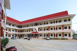 un grand bâtiment blanc avec un toit rouge dans l'établissement SC Palace Chiangrai Hotel, à Ban Du