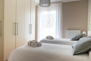 2 witte bedden in een slaapkamer met een raam bij CASA CON VISTA in Potenza Picena