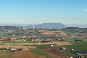 una vista aérea de un campo con montañas en el fondo en CASA CON VISTA, en Potenza Picena