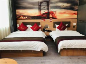 twee bedden in een kamer met een schilderij aan de muur bij Thank Inn Hotel Inner Mongolia Baotou Donghe Haode Trade Plaza in Baotou