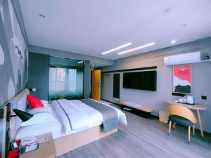 Thank Inn Hotel Yunnan Kunming Wuhua Puhuiyuan في Heilinpu: غرفة نوم بسرير كبير ومكتب