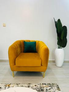 a yellow couch in a living room with a plant at Entire Furnished Apartment Unit in Kira in Kira