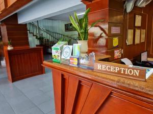 a restaurant counter with a sign that reads reception at Phu Nga Hotel in Natai Beach
