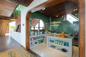 eine Küche mit grün gefliesten Wänden und einem offenen Durchgang in der Unterkunft Nap Am - Dalat in Ấp Kim Thạch