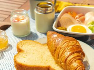 a plate of breakfast food with bread and eggs at The Beach Terrace Hotel AO Ishigaki in Ishigaki Island