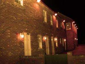 un edificio de ladrillo con luces encendidas por la noche en The Downe Arms en Snaith