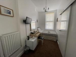 mały pokój z łóżkiem i biurkiem w obiekcie Gateway Hotel w Londynie