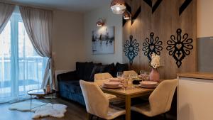 a living room with a table and a couch at VacationClub - Apartamenty Zakopiańskie Apartament 44 in Zakopane
