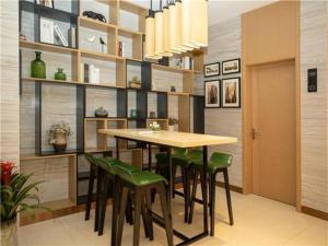 uma sala de jantar com uma mesa e cadeiras verdes em City Comfort Inn Yangzhou Jiangdu North Limin Road em Jiangdu