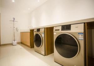 a laundry room with two washing machines in it at City Comfort Inn Yangzhou Dongguan Street Heyuan in Yangzhou