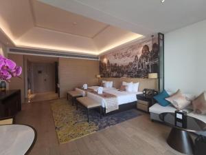 シアヌークビルにあるNanhai International Hotelのベッドとソファのあるホテルの部屋