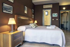 una habitación de hotel con 2 camas y una lámpara en Hotel Utopía, en Benalup-Casas Viejas