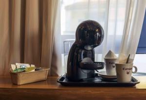 uma cafeteira e uma chávena sobre uma mesa em Hotel Utopía em Benalup-Casas Viejas