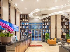 um átrio de uma biblioteca com cadeiras e mesas em VX Hotel Wuxi Xinwu District Executive Center Wanda Plaza em Xin'an