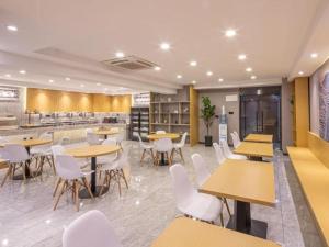 um restaurante com mesas e cadeiras e uma cafetaria em VX Hotel Wuxi Xinwu District Executive Center Wanda Plaza em Xin'an